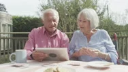 4K Happy Senior Couple Laughing At Something They See On A Computer Tablet Stock Footage
