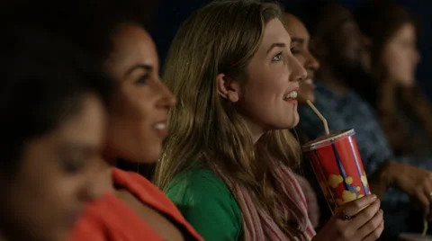 4K Happy young female friends watching a film in movie theatre Stock Footage