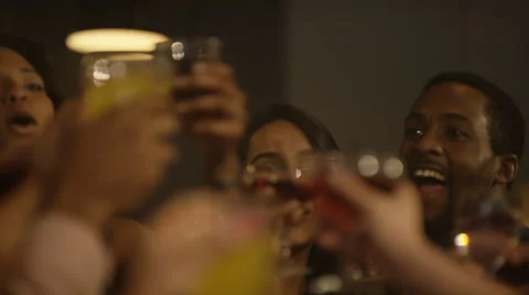 4K Happy young party crowd raise their glasses for a toast in city bar Vidéo 64699658