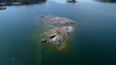 4K HD Aerial view with drone flying low over rocky islet following bird Stock Footage 78631348