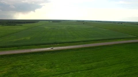 4K HD Aerial view two lane small road with cars driving by green field landscape Stock Footage 64660448