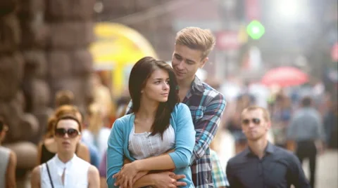 4K &amp; HD resolutions: Lovers stand above the crowd stream at the street, summer Stock Footage 40380240