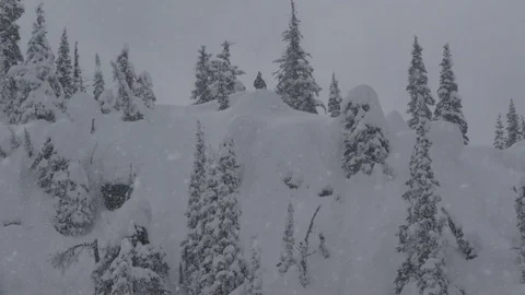 4K: Heavy Snow Fall with Man on Mountain Peak Stock Footage 72841380