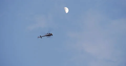 4K HELICOPTER HOVERING IN DUSK SKY WITH MOON Stock Footage 131461692