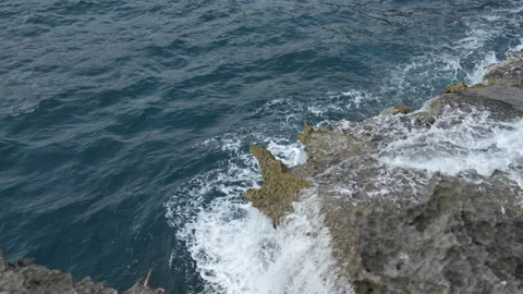 4K high angle slow motion of ocean waves washing over sharp volcanic rocks 스톡 동영상 337088737