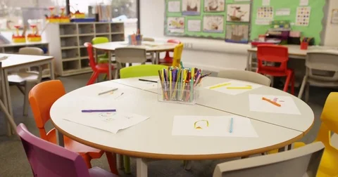 4K High angle view colored pens &amp; children's drawings on table in primary school Stock Footage 74231173