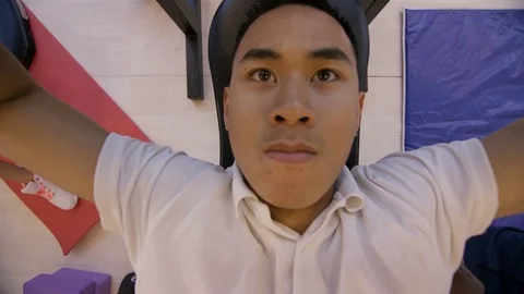 4K High angle view of man lifting weights with personal trainer in the gym Stock Footage 75884320