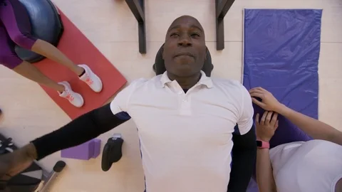 4K High angle view of man lifting weights with personal trainer in the gym Stock Footage 75885675