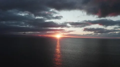 4K high drone shot over the sea off the Welsh coast during sunrise 動画素材 296803779