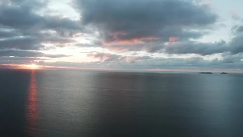 4K high drone shot over the sea off the Welsh coast during sunrise Видео 296803808