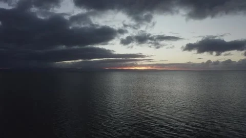 4K high drone shot over the sea off the Welsh coast during sunrise 库存影片 296804416