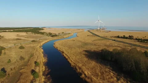 4K. High flight over blue river and fields towards wind turbines and the sea. 스톡 동영상 63136234