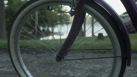 4K High Quality Rack focus bike spokes to a lake at dawn Pro Res 444 (Color Stock Footage 138539712