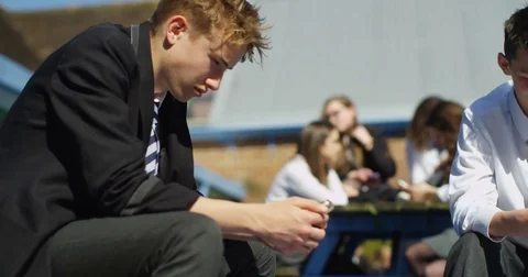 4k, High school students are sitting together and texting on their cell phones. Stock Footage 77285610