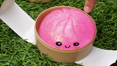 4K horizontal video of a child's hands squishing a pink glitter dumpling Stock Footage 342077577