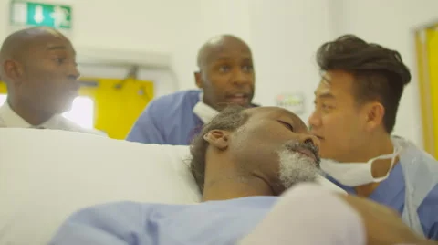 4K Hospital emergency team rush a patient on a gurney to operating room Stock Footage