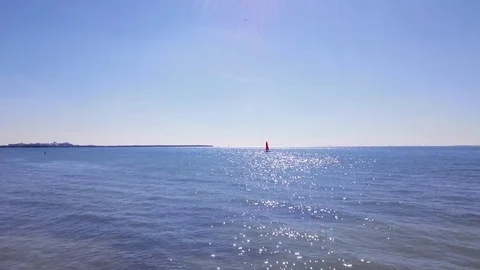 4k Hovering drone over ocean, sailboat in distance Stock Footage