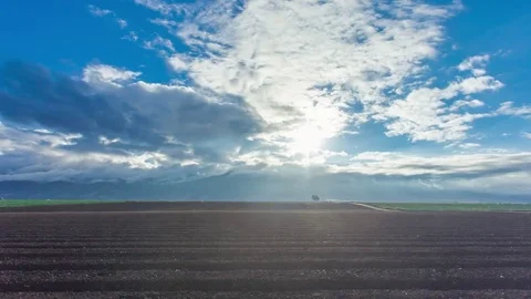 4K Hyperlapse shot in the field with sunshine through clouds and mountains Stock Footage 70571814