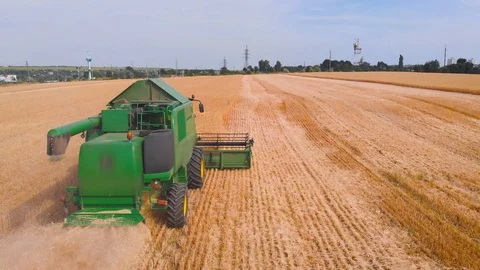 4K impressive flight over a working combine harvesting tons of ripe barley Stock Footage 126656564