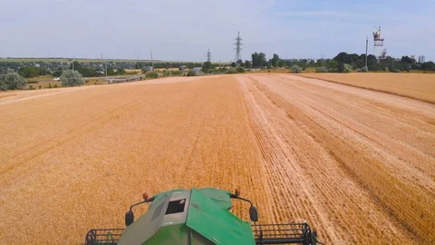 4K impressive flight over a working combine harvesting tons of ripe barley Stock Footage 126656748