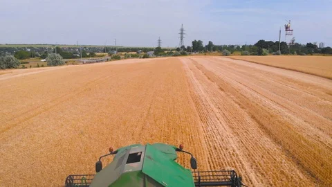 4K impressive flight over a working combine harvesting tons of ripe barley Stock Footage 126656824