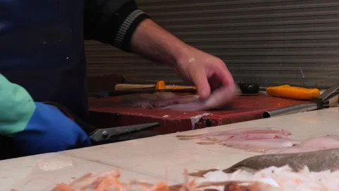 4k interior close up tracking shot of a fishmonger cleaning small fresh white Stock Footage 124252332