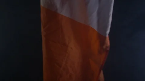 4K A Irish Flag Being Waved Around A Dark And Smokey Room Stock Footage 123703400