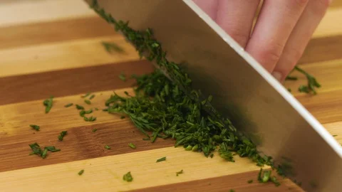 4K. It is slicing of the dill by a kitchen steel knife. Stock Footage 128329100