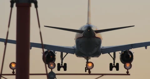 4K JET LANDS AT SUNSET Stock Footage 64144610