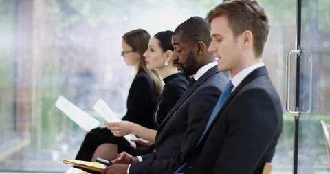 4K Job applicants waiting at interview, businessman gets up to take a call Stock Footage 110152091
