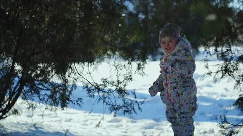 4K The kid is standing in the park full of snow and after runs laughing Stock-Footage 102443228