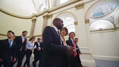 4K Large diverse group of business delegates walking through conference building Stock Footage 73054394