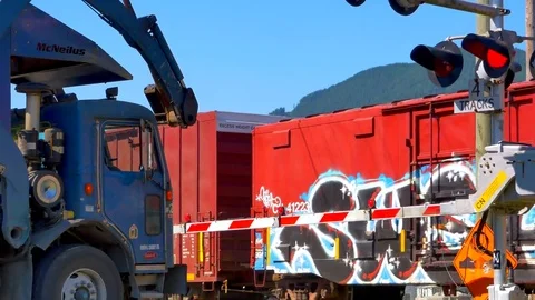 4K Large Truck Stops at Train Crossing, Moving Train Storage Cars, Red Lights Stock Footage 69178482