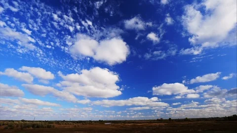 4K Light clouds in a blue sky over a field. Windy autumn sky. 動画素材 97039906