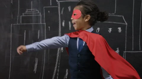 4K Little boy superhero in front of blackboard with drawings of buildings Stock Footage 59743866