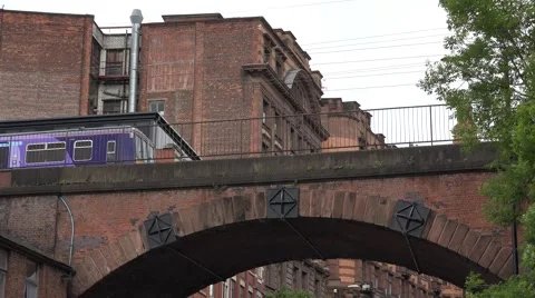4K Local train pass suspended bridge Manchester old town beautiful red facade UK Stock Footage 60161095