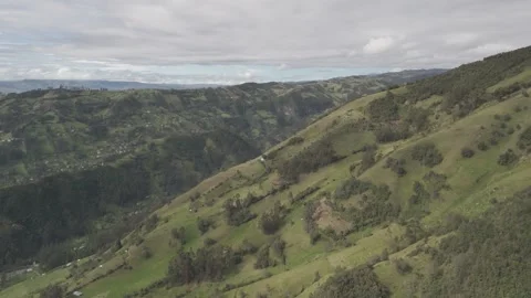 4K Log Drone Approaching Green Mountain revealing Valley with Houses Ecuador Stock Footage 271372878