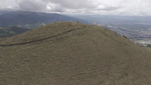 4K Log Drone Approaching Two People Standing on Brown Hillside Ecuador Stock Footage 271372625
