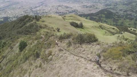 4K Log Drone Following Two Mountain Bikers Riding Down a Mountain Ridge Ecuador Stock Footage 274040465
