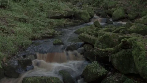 4k Long Exposure Time-Lapse of Small River/Creek Surrounded by Mossy Rocks Stock Footage 70734428