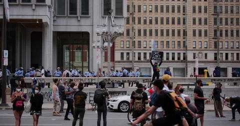 4K LONG SHOT OF COPS OBSERVING PROTESTORS DURING THE GEORGE FLOYD PROTEST Video stock 131459316