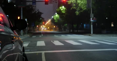 4K LONG SHOT OF EMPTY CITY STREET AT NIGHT WITH CAR IN FOREGROUND Stock Footage 131124847