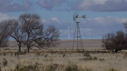 4K long shot of an old windmill and modern windmills on the New Mexico prairie Stock Footage 229080848