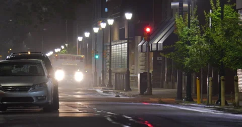 4K LONG SHOT RACK FOCUS OF AMBULANCE ON STREET AT NIGHT Stock Footage 131126942