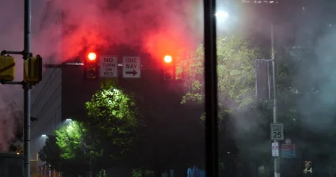 4K LONG SHOT OF TRAFFIC LIGHT AT NIGHT WITH STEAM RISING Stock Footage 131109497