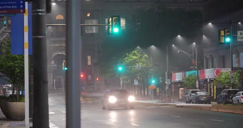 4K LONG SHOT OF TRAFFIC LIGHT INTERSECTION ON A HAZY NIGHT Stock Footage 131126032