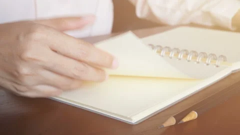 4K loop. finger hold the corner of the paper and then flip the page over. Stock Footage 132087516