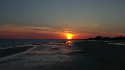 4k Low Aerial with Forward Motion Along Sandbars Reflecting a Red Sunset Stock Footage 154967235
