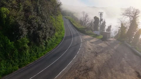 4K Low Altitude Drone Flight Along a Foggy Road in Cinematic Landscape Stock Footage 339243516