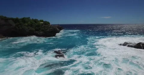 4K LOW ANGLE AERIAL FLY BY OF TOURIST STANDING ON ROCK CLIFFS IN BALI Stock Footage 59999584